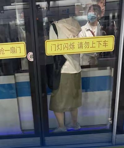 上海地铁一女子被夹在屏蔽门与车厢门之间，目击者：快关门时她跑了上去，夹了约1分钟，工作人员迅速赶到，无人员受伤